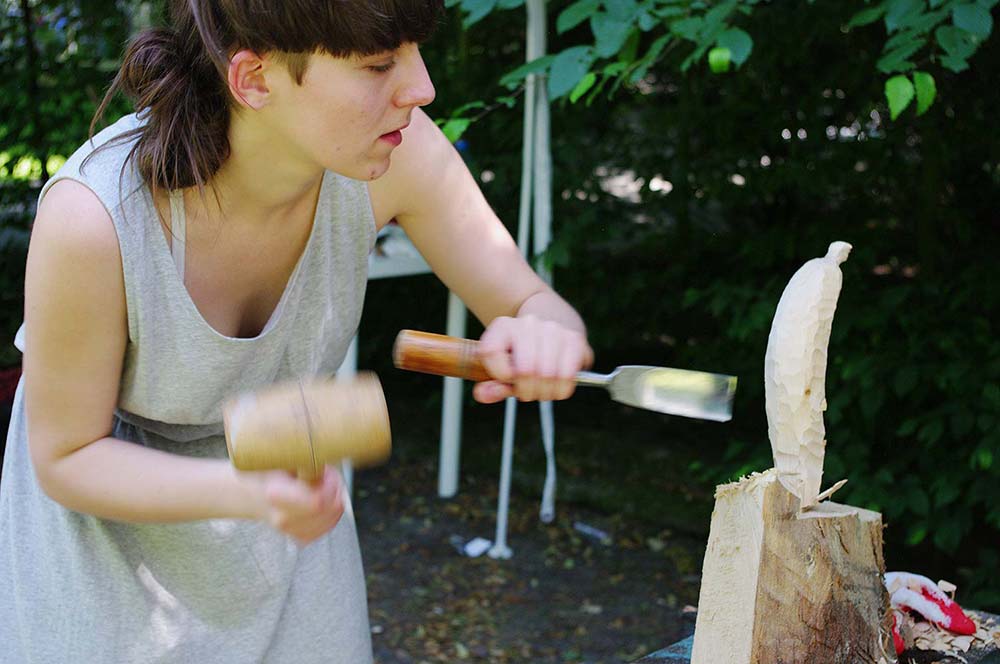 dziewczyna rzeźbiąca banana w drewnie
